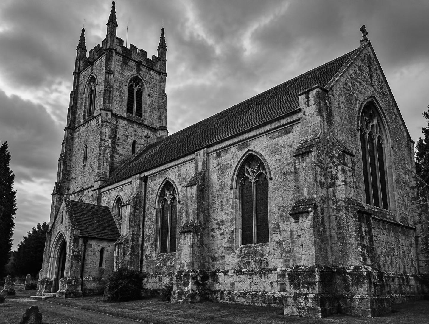 A stone church photographed from an angle in black and white